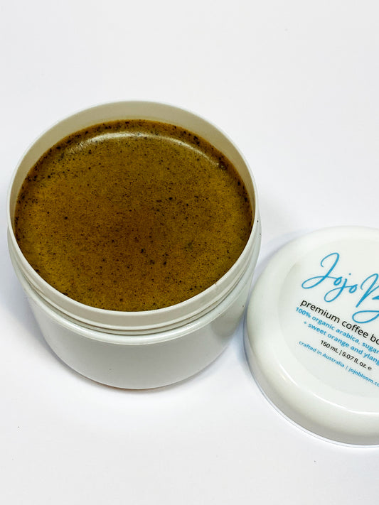 Jojo Bloom premium coffee body scrub 100% organic jojoba oil, with shea butter, arabica coffee and sugar as the exfoliate material, matched  with sweet orange and ylang ylang essential oils. 150mL. Exceptional for exfoliating dry scaly skin (removing dead skin cells) while the jojoba oil offers soothing hydration, moisturising and rejuvenation.